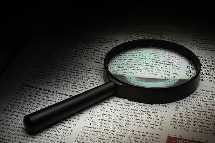 magnifying glass in top of a news paper